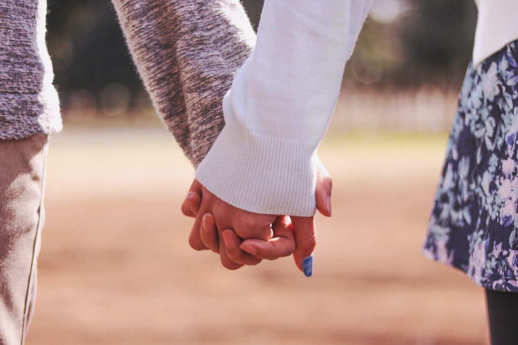 公園で仲良く手をつなぐ付き合いたてのカップルのフリー写真画像